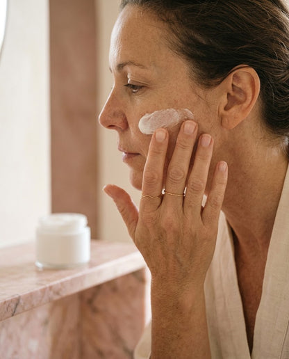 Mujer extendiendo su crema hidratante después del sérum